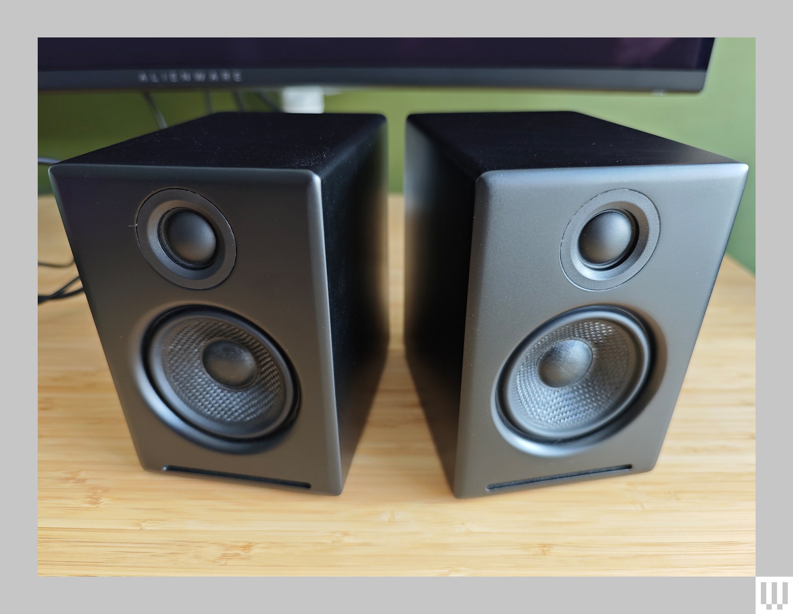 Audio Engine A2 Plus two small black speakers on top of a wooden desk