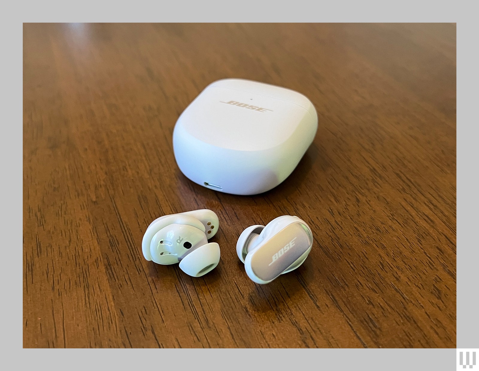 White Bose QuietComfort Ultra Earbuds next to charging case