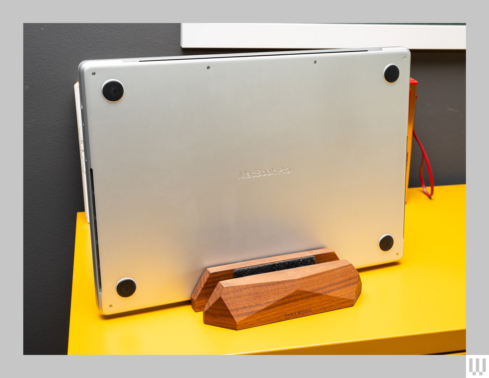 Oakywood Dual Laptop Dock a wooden block holding a slim silver laptop on its side