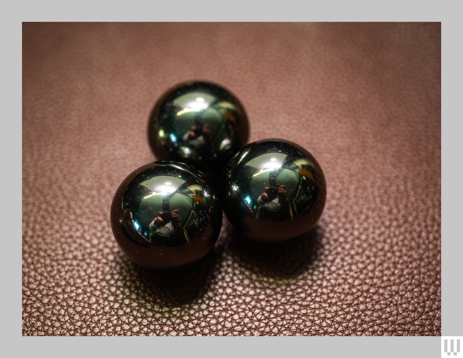 Speks Supers 33mm Magnet Balls 3 shiny black magnetic balls on a brown leather pad