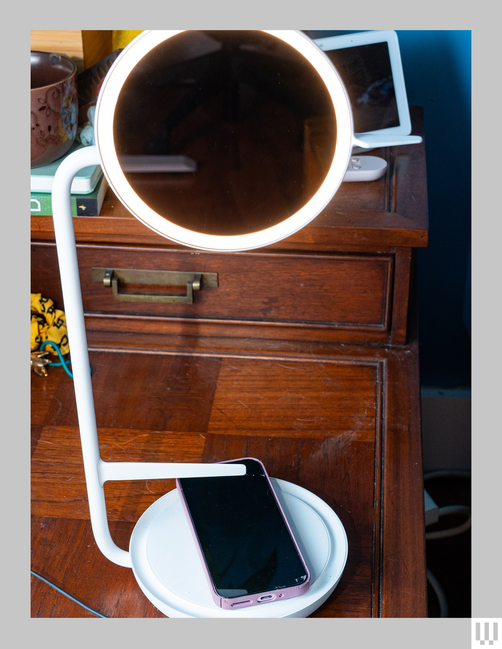 Steelcase Eclipse Light a circular light with light around the rim attached to a rod leading down to a circular base to...