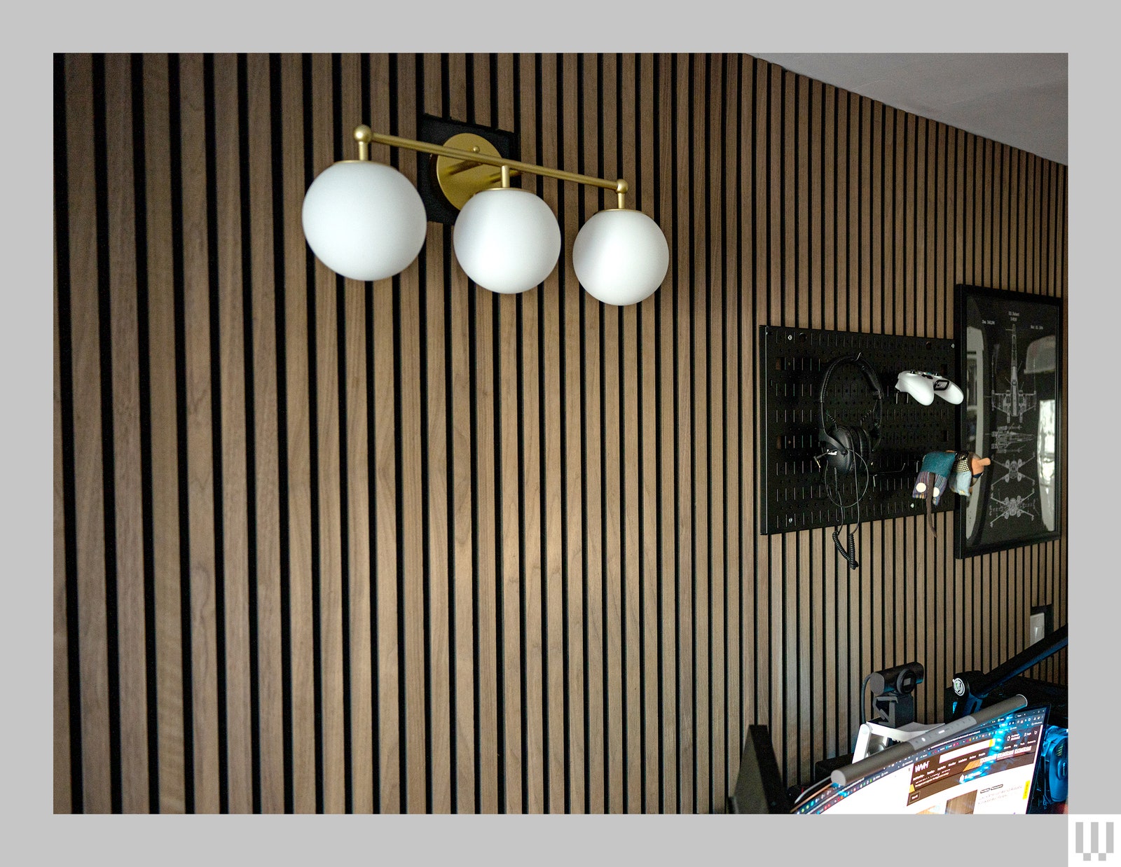 Wood Veneer Hub Luxury American Walnut Acoustic Slat Wood Panels in a room with white globe lighting with bronze...