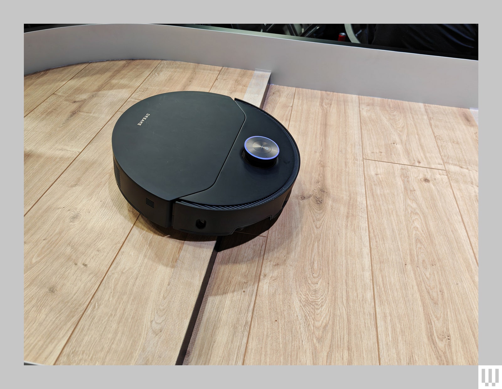 Black discshaped robot vacuum going down stairs