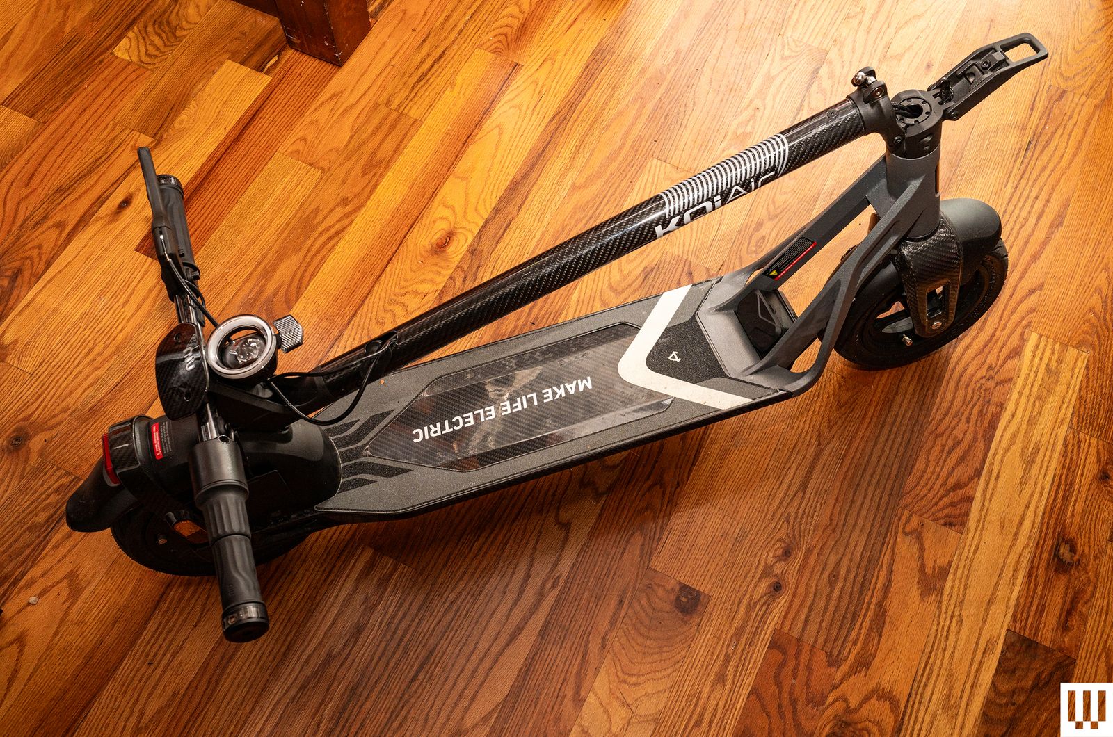 Niu KQi3 Air Kick Scooter folded up and sitting on hardwood floor