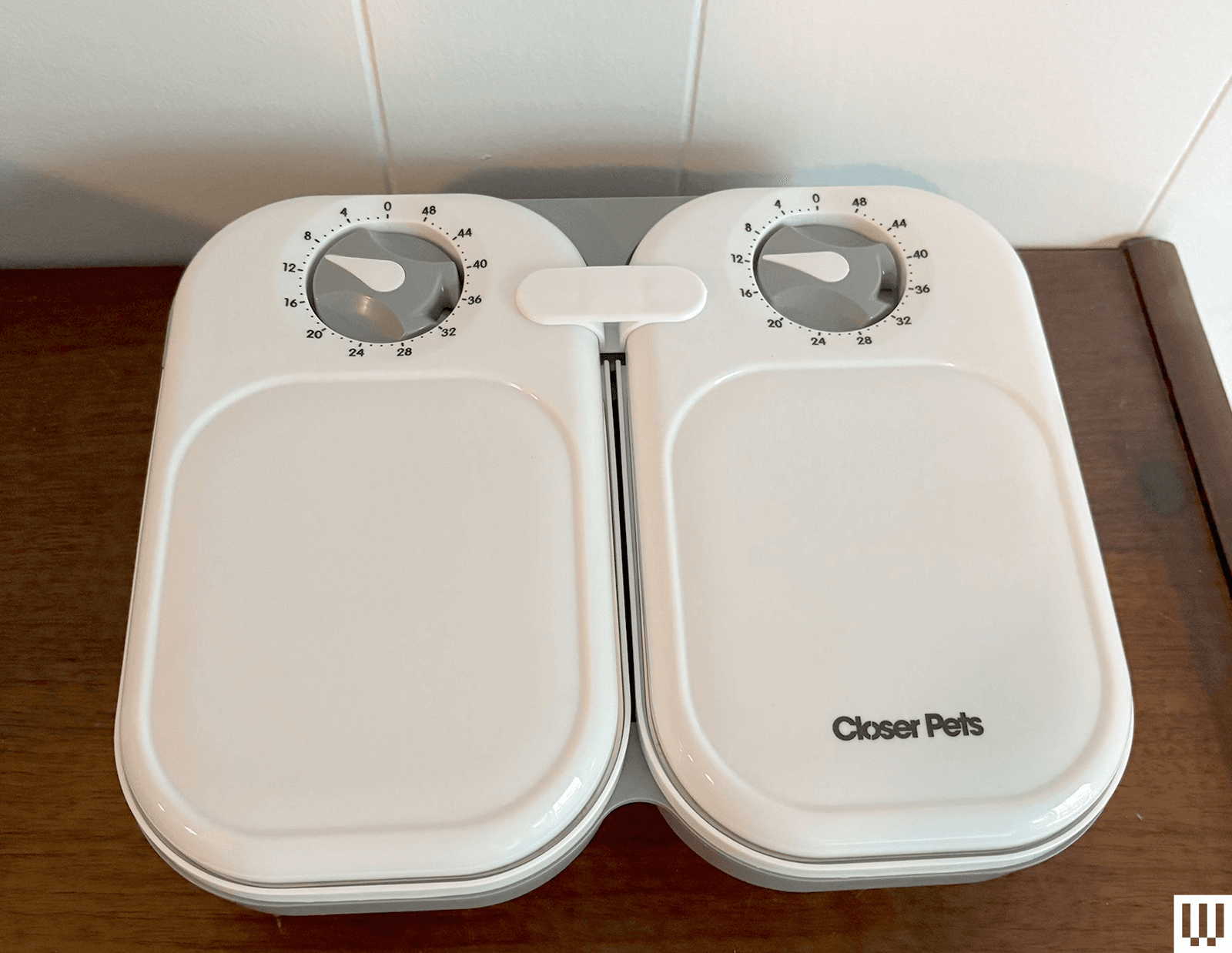 Front view of the Closer Pets C200 Automatic Pet Feeder two white ovalshaped containers with a timer dial at the top of...