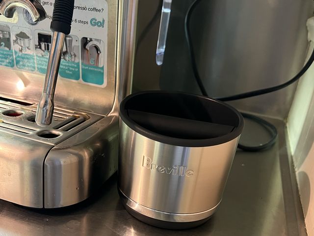 Breville Knock Box sitting beside a silver espresso maker