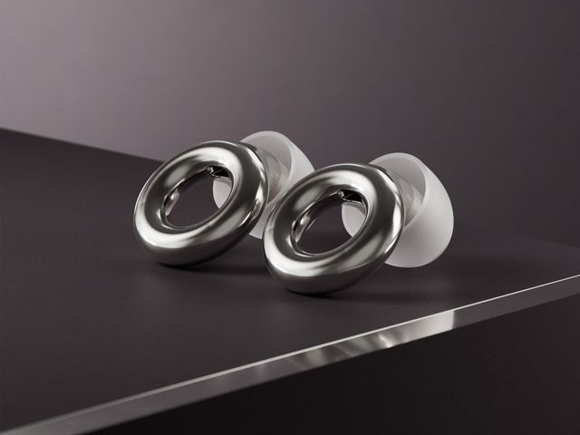 Loop Experience 2, dark grey earplugs with white cushions, sitting on a black surface