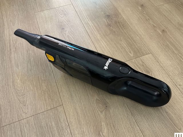 Shark Ultra Cyclone Pet Pro Plus, a small black handheld vacuum, on a wooden surface